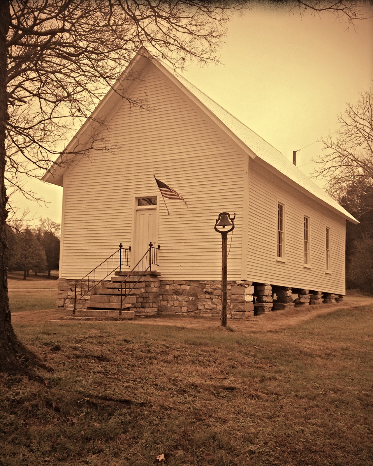 Sepia-toned image of a restored circa 18-- one-room schoolhouse located on Foxfire Farm in Lynnville, TN.