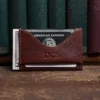 no 33 vintage brown wallet showing the front side - in front of books on wood shelf