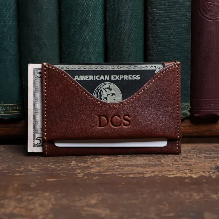 no 33 vintage brown wallet showing the front side - in front of books on wood shelf