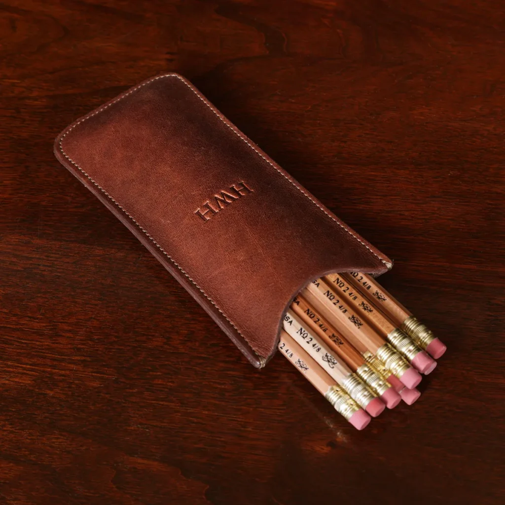 leather pencil case with 12 pencils on a wooden table