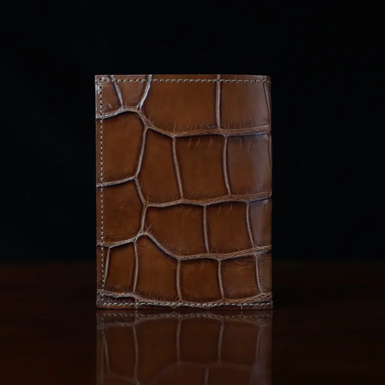 No. 2 card wallet in Vintage Brown American Alligator - ID 001 - back view on a wood table and dark background