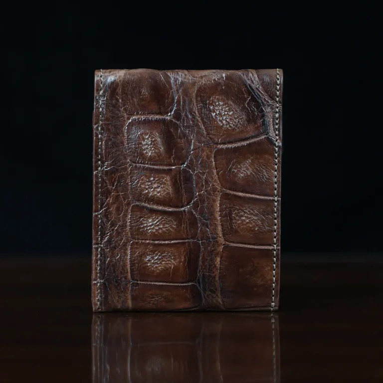 Front pocket wallet with flap in brown American Alligator - back view - 002 - on wood table with a dark background