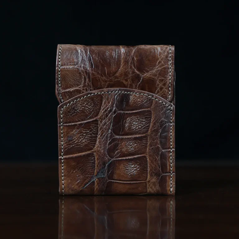 Front pocket wallet with flap in brown American Alligator - front view - 002 - on wood table with a dark background