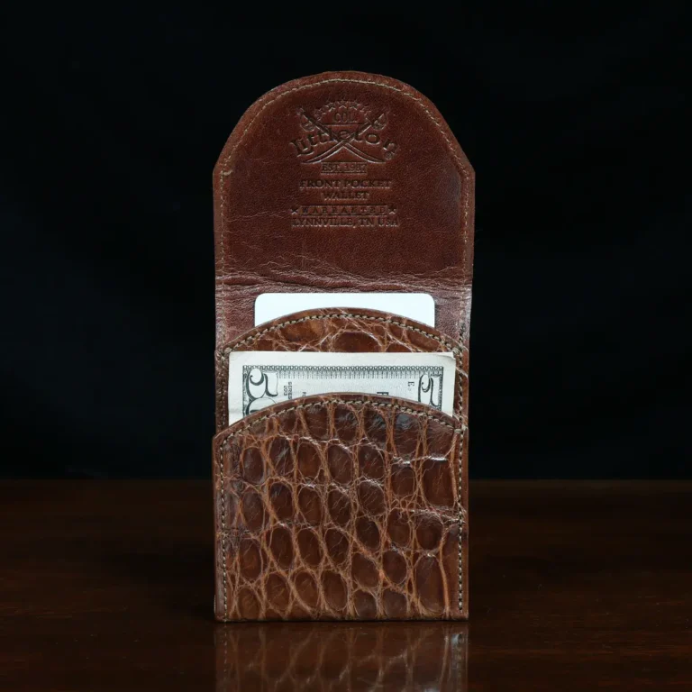 Front pocket wallet with flap in brown American Alligator - front open view with money and card - 002 - on wood table with a dark background