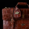 No. 1943 Navigator Briefcase in Vintage Brown American Alligator - Serial number 011 - front view with luggage tag