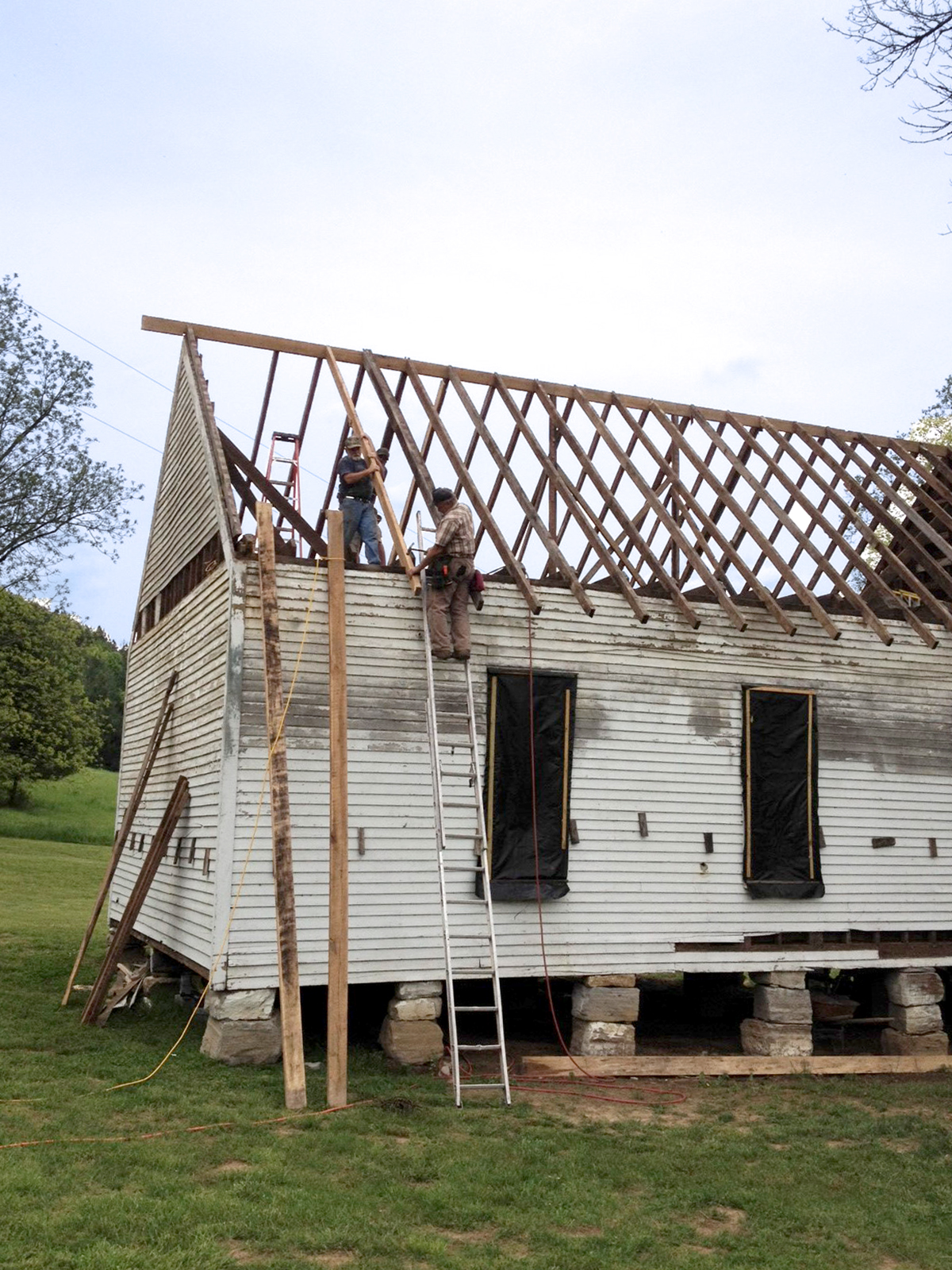 Men building rafters for the roof of the one-room schoolhouse on Foxfire Farm in Lynnville, TN