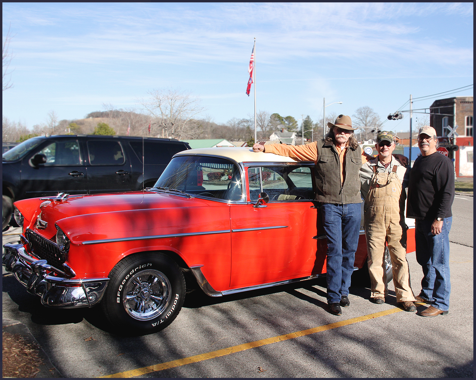 Colonel Littleton and two men standing next to a red 1955 Chevy car.