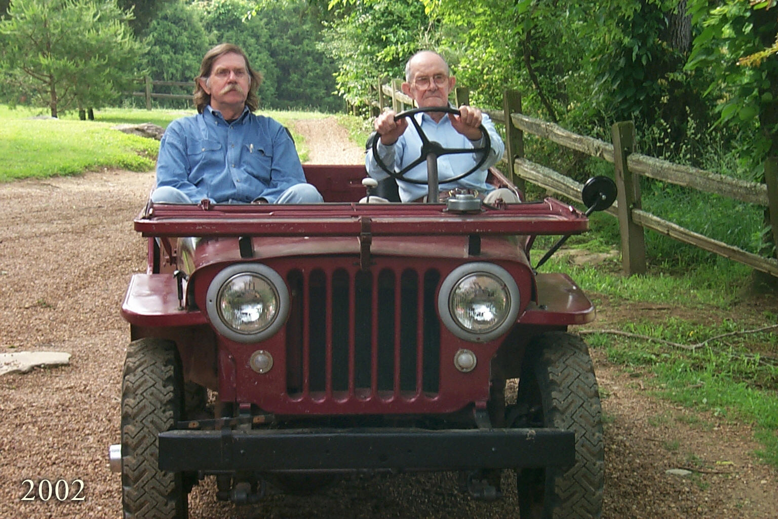 Colonel riding in an old jeep with his dad in 2002