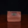 no1 brown leather small zip it bag - front view - on wooden table
