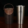 A tumbler with the Col. Littleton logo engraved next to a Tobacco Brown American Buffalo tumbler that has American Alligator trim.