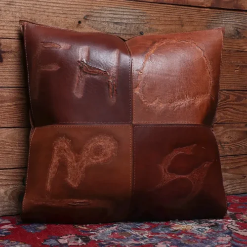 front view of a two tone branded leather pillow