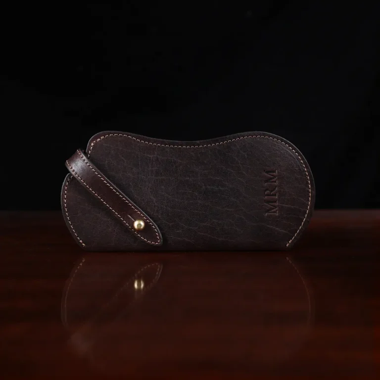 tobacco buffalo leather No. 2 Eyeglass Case on wood table with dark background - front view