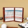 no 1 golf score card holder - open view with score card - golf balls - golf tees - glove and golf club on light background